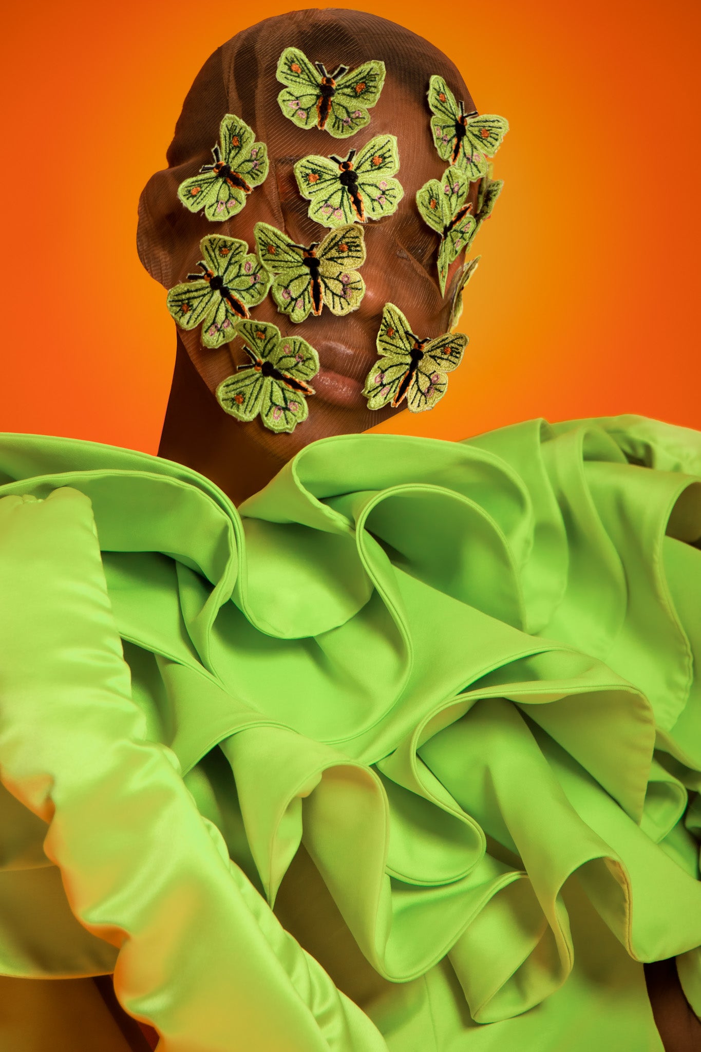 A lime green dropped waist maxi dress features exploded ruffles on the chest to shoulder and back with a buttcape.