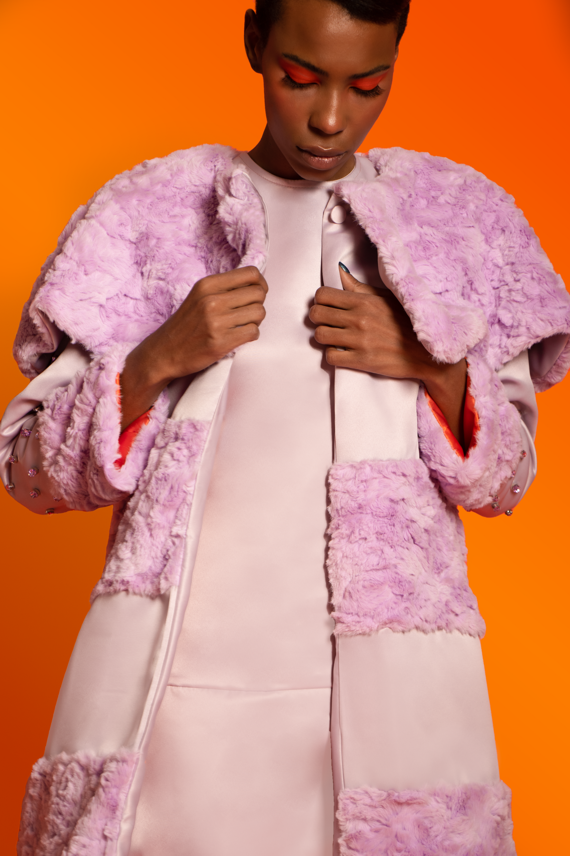 Zoom in. A light purple raccoon coat with faux fur and taffeta features embellished crystal sleeves and orange lining.